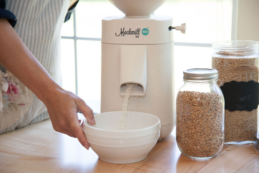 Mockmill Grain Mill Grinding Grain σε ένα λευκό μπολ.