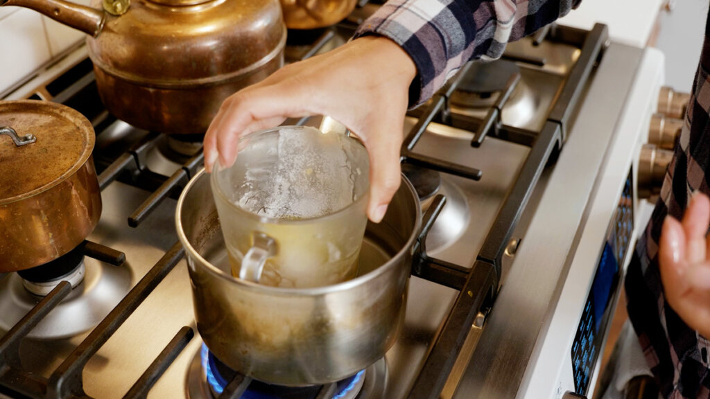 Ένα κύπελλο μέτρησης Pyrex σε ένα διπλό λέβητα στη σόμπα.